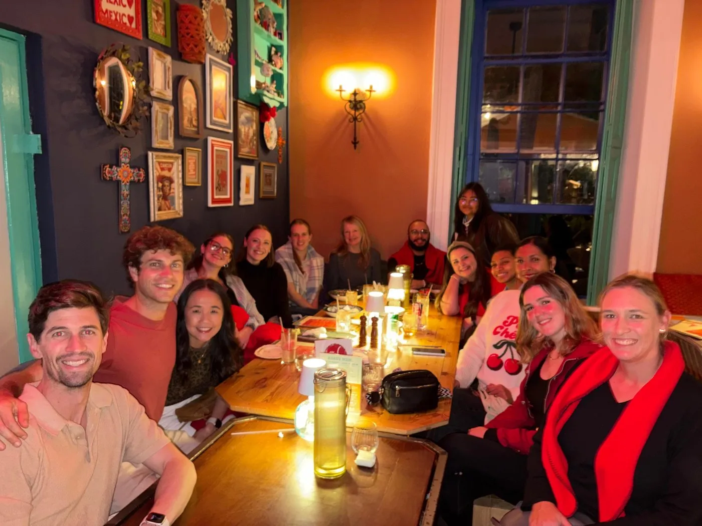 A long table of smiling Sidekicks at a team dinner